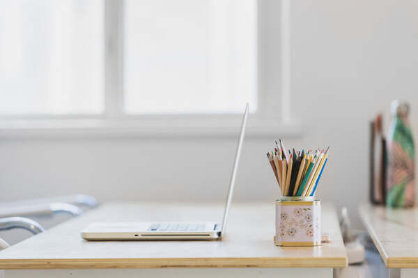 A tidy desk with a notebook and natural light